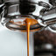 Attendant Espresso extraction through a naked porterfilter. Showcasing the rich vibrant texture of espresso.